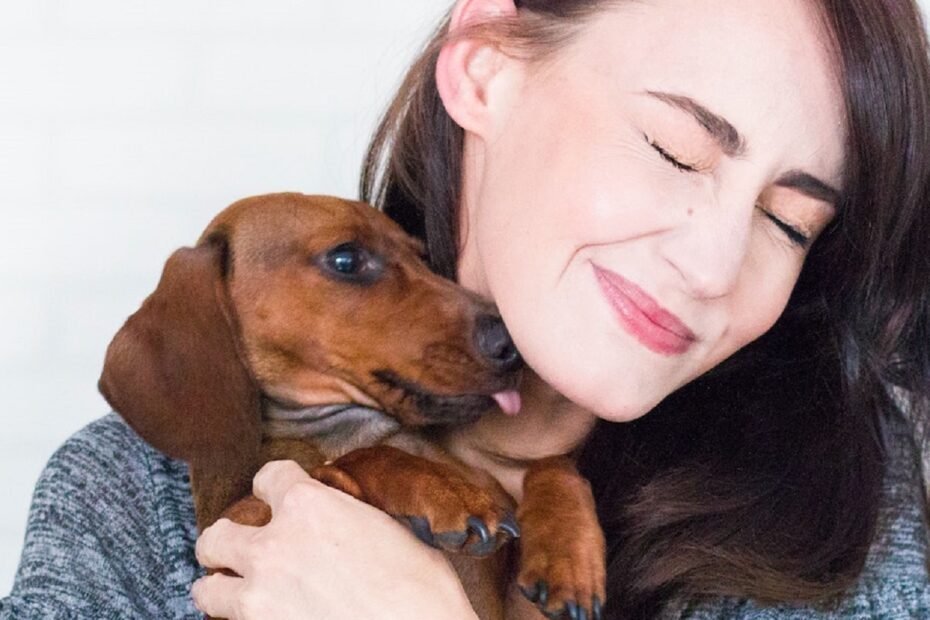 woman-holding-dachshund-dog-up-to-her-chin